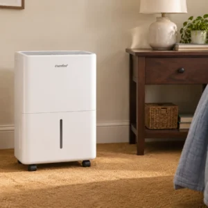 Le déshumidificateur Comfee Aqua Dry 12 posé au sol dans une petite chambre d’amis.
