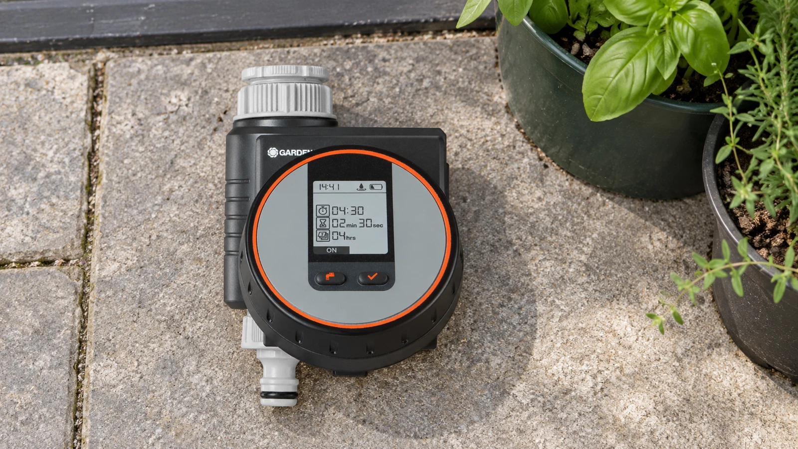 GARDENA Flex 1890-20 couché sur une dalle de terrasse avant pose, pour programmer de courts cycles d’arrosage en pots.