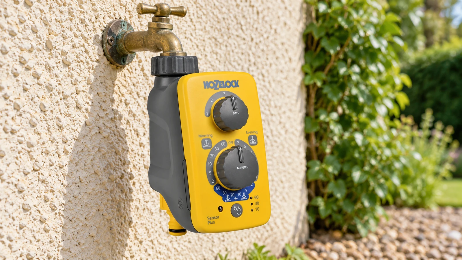 Hozelock Sensor Controller Plus 2214 fixé sous un robinet au jour naturel, pour déclencher l’arrosage au rythme du soleil.